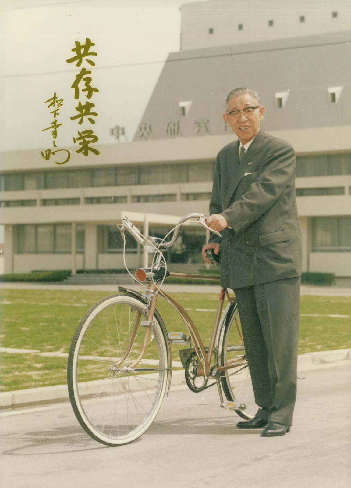 写真：1965年 自転車生産100万台の達成を記念して贈られた、松下電器産業（当時）製の自転車「ニューグランディ」と一緒に写る創業者 松下幸之助。