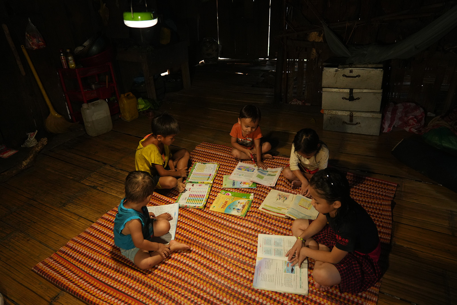 Photo: Local children using the solar lantern to study at night
