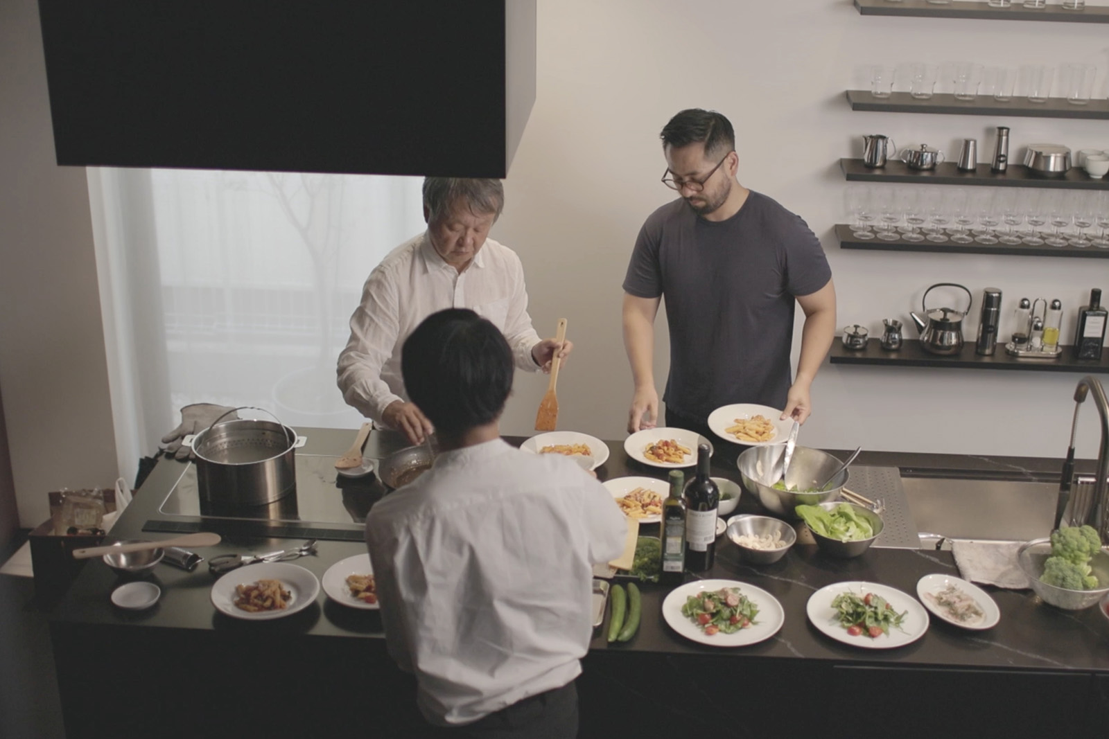 写真：アトリエに集ったスタッフの方々と調理を楽しむ深澤氏